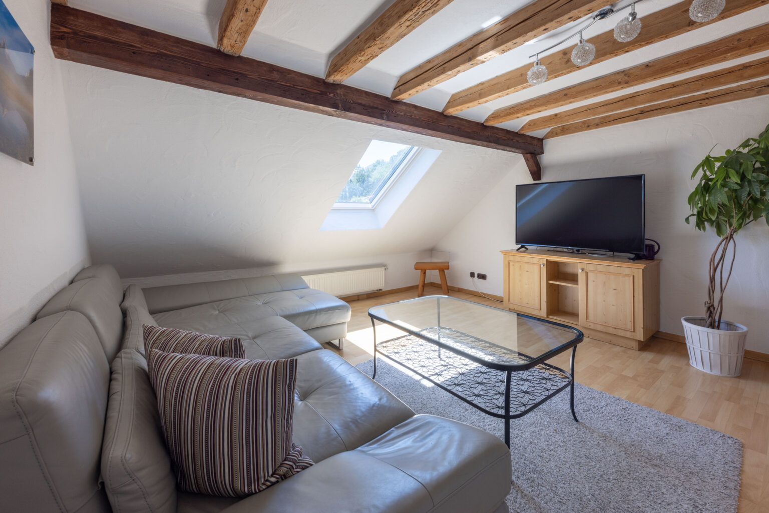 Heller Wohnraum mit Holzdeckenbalken