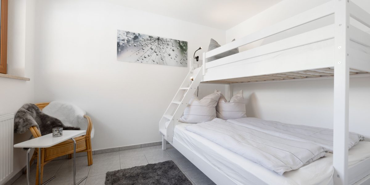 Helles Zimmer mit Etagenbett und Stuhl