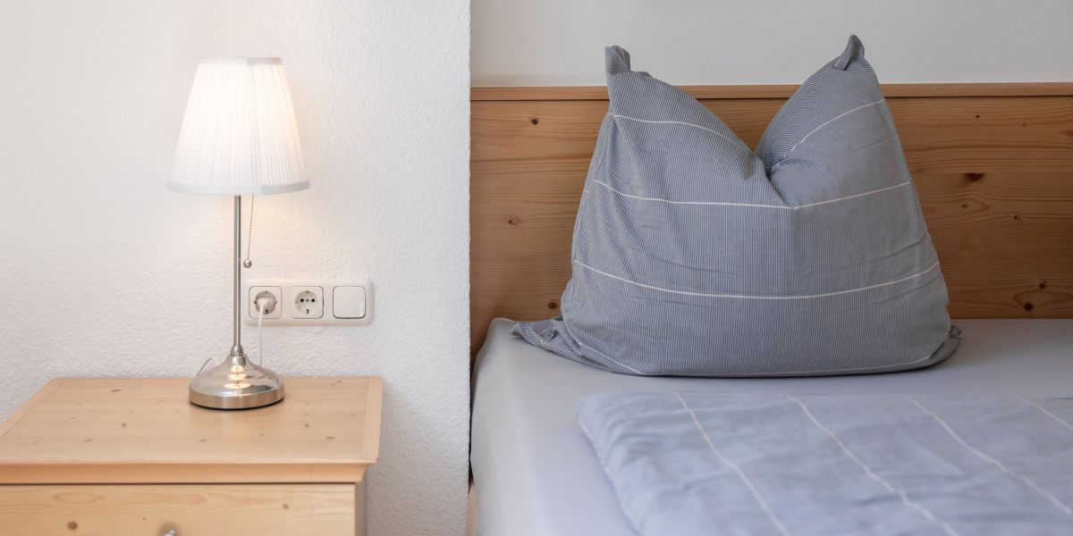 Helles Schlafzimmer mit Bett und Lampe